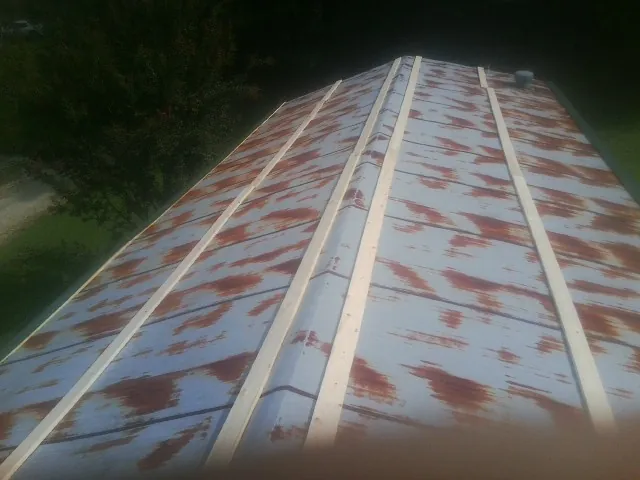 Rusted metal roof panels with new wood purlins before replacement — Storm Damage Roof Repair in Cullen by Roofing Brothers