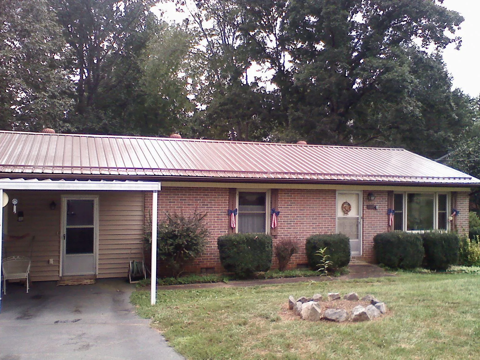 Bronze metal roof and carport on a brick ranch home — Roof Repair work by our crew in Cullen